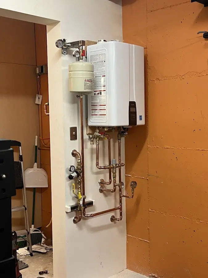 Plumbing technician inspecting water heater connections in Sun Village